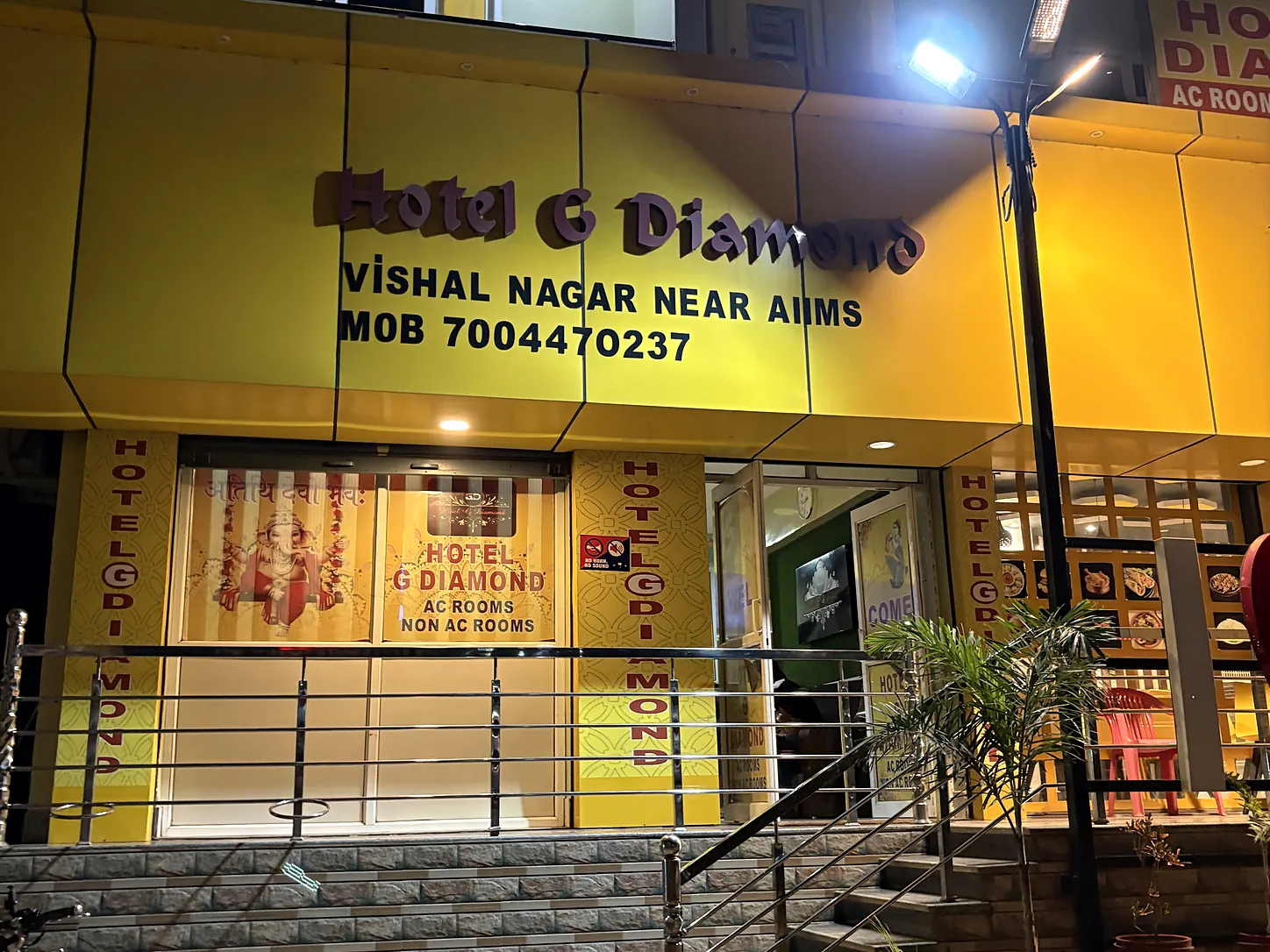 Lit entrance and signage of Hotel G Diamond at night